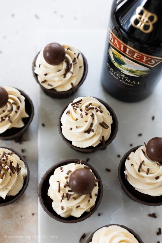 Multiple Baileys Cupcakes with a bottle of baileys