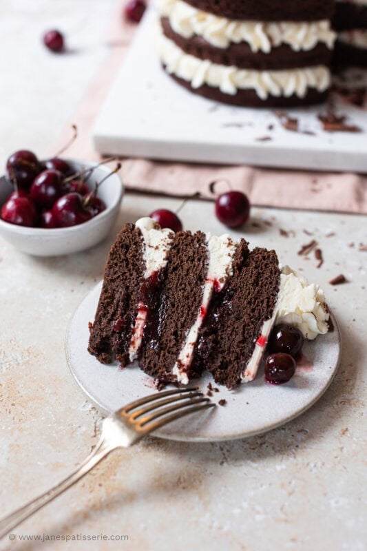 A slice of black forest fudge cake on a plate with a fork