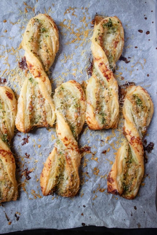 Alternate rows of Pesto and Cheese Straws on parchment paper