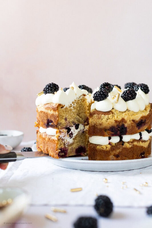 Knife cutting into apple blackberry crumble cake