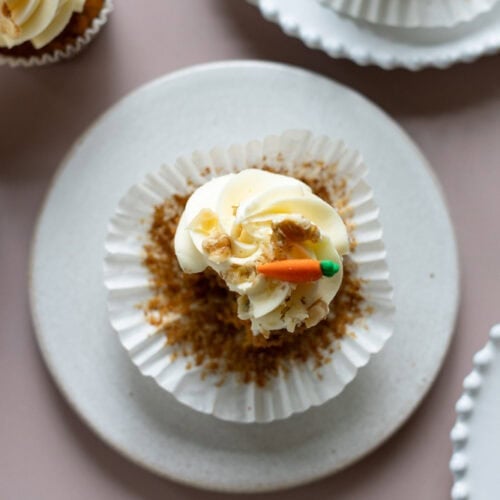 A top down shot of a carrot cake cupcake with a bite missing