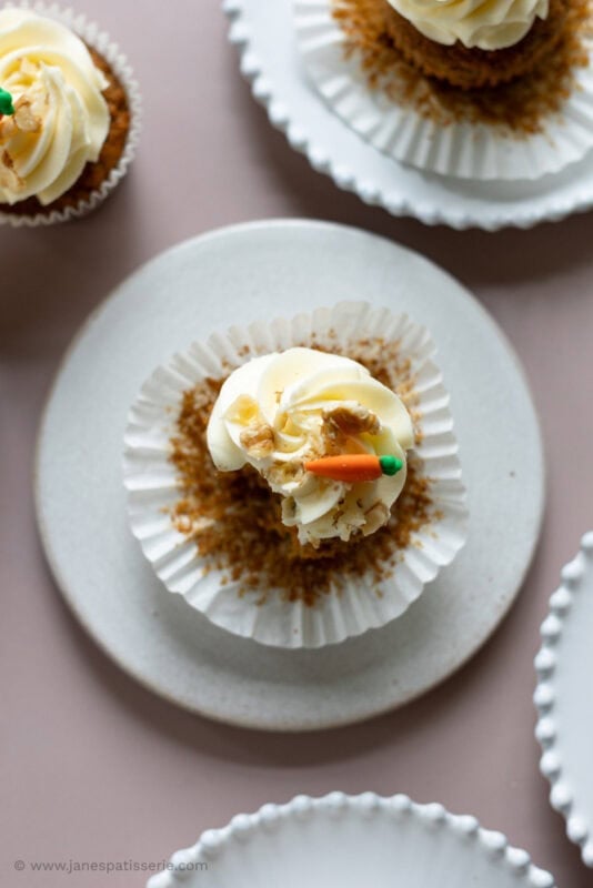 A top down shot of a carrot cake cupcake with a bite missing