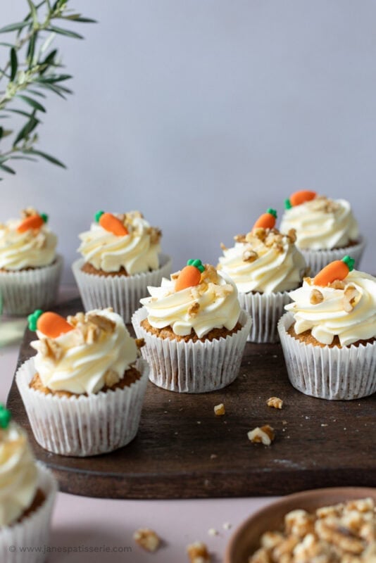 Multiple carrot cake cupcakes in white cases