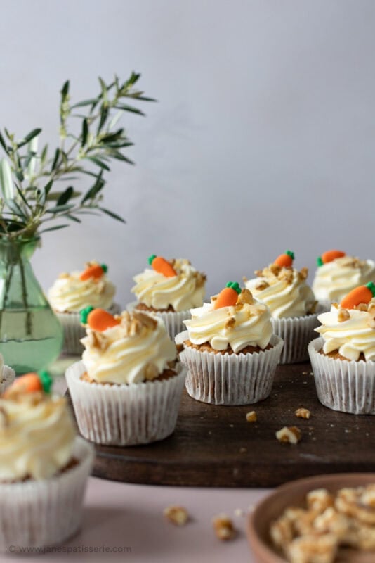 Scattered carrot cake cupcakes on a chopping board