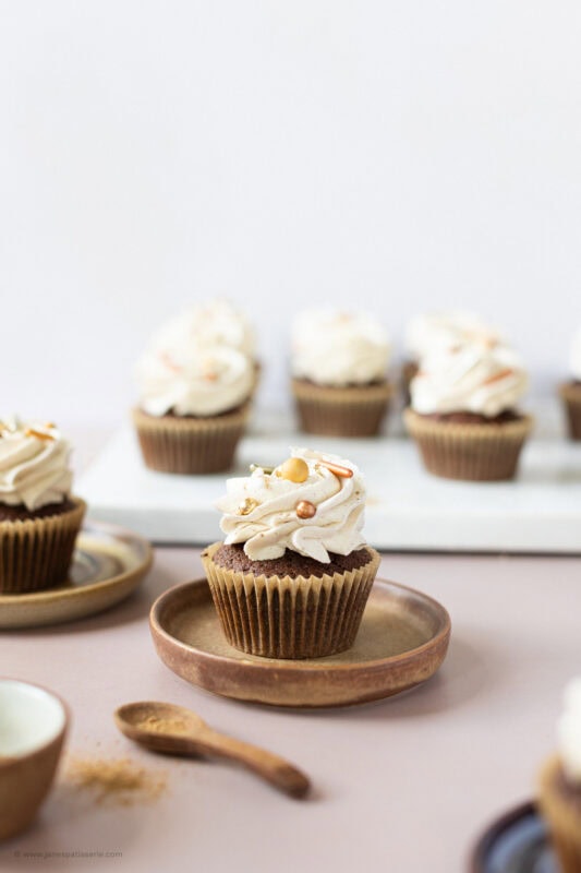 A side shot of a chocolate chai cupcake on a plate