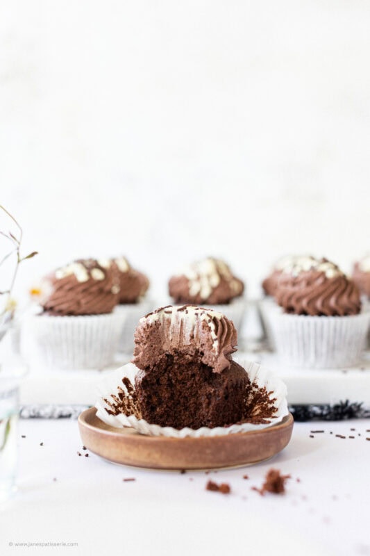 A bite taken from a chocolate cupcake