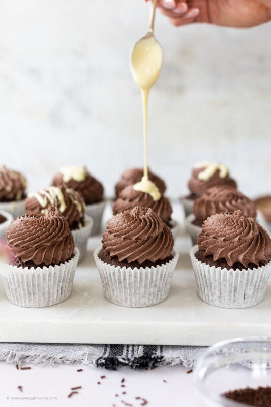 Drizzling White chocolate onto Chocolate Cupcakes