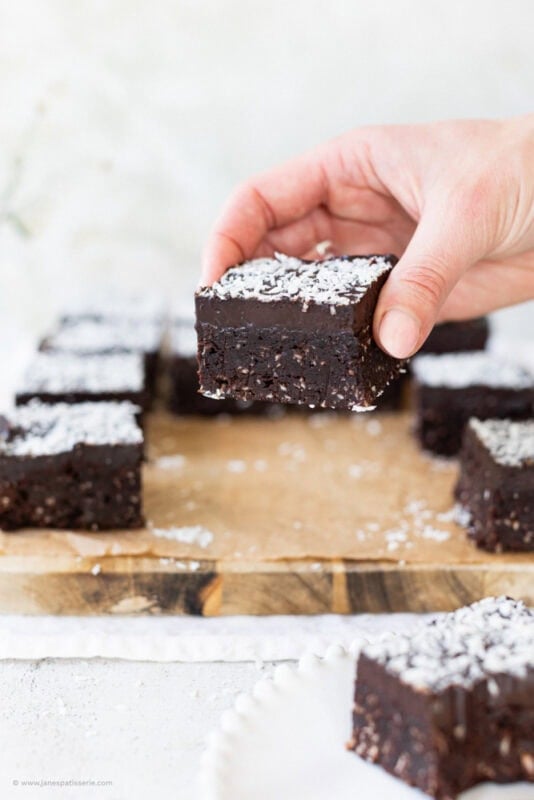 A hand holding a coconut brownie