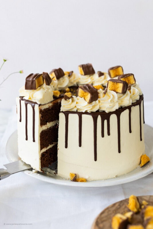 A slice cut from the Crunchie Drip Cake