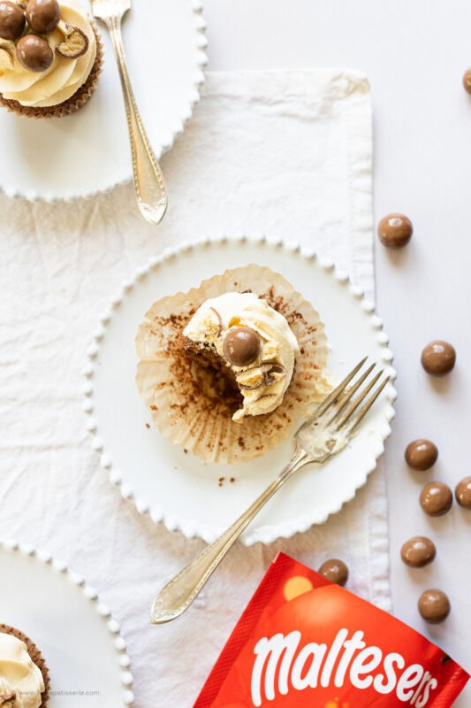 A top down shot of a bite missing from a malteser cupcake