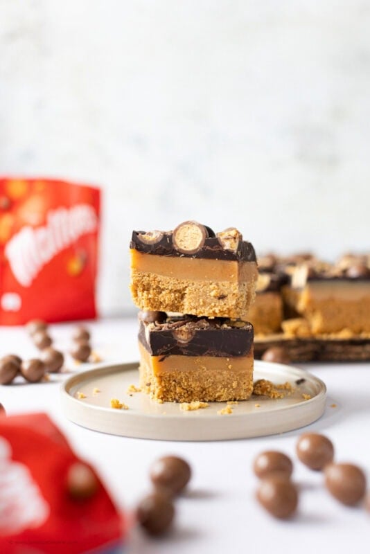 Two Malteser Millionaires Shortbread stacked on a plate