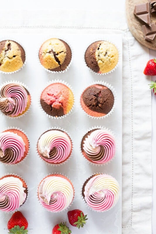 Rows of half decorated Neapolitan Cupcakes