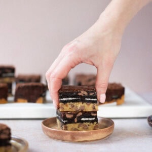 A hand taking a Slutty Brownie from a plate