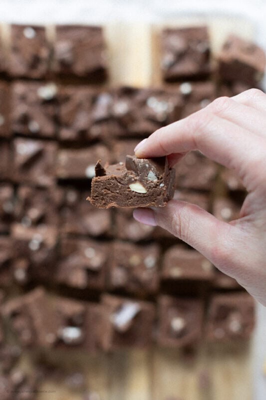 A hand holding a single Toberlone Fudge square