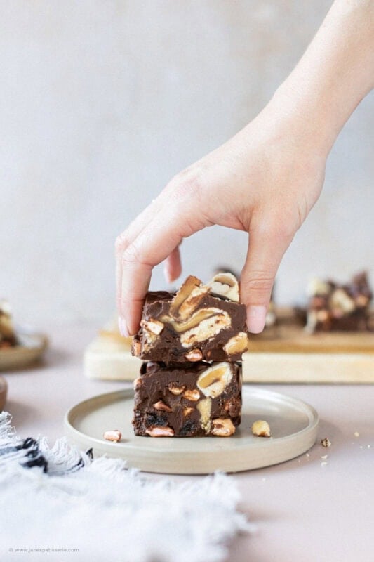 A hand taking a Rocky Road from a plate