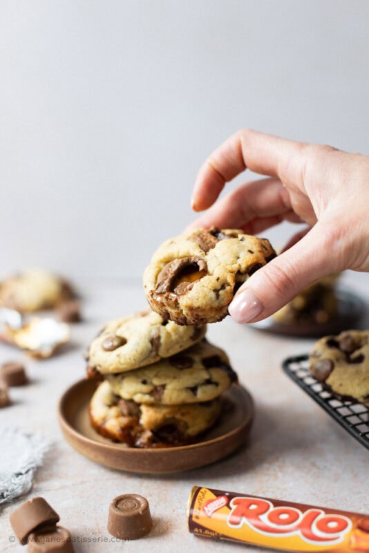 A hand taking a Rolo Cookie from a plate