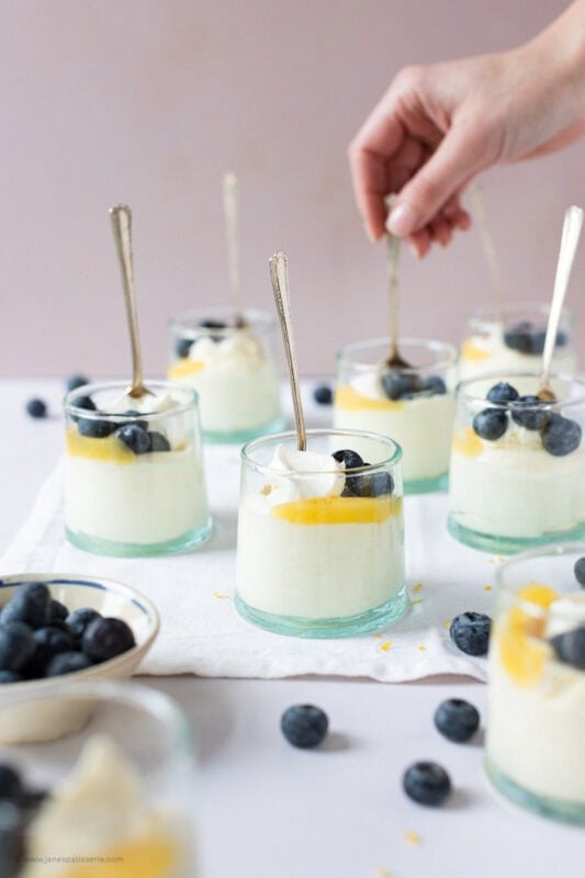 A hand holding a spoon in the Lemon Curd Mousse