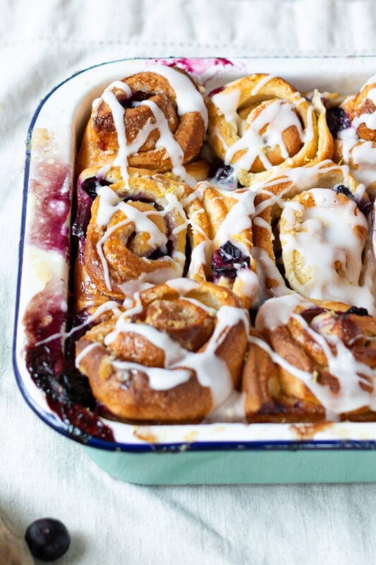 The corner of a tray of lemon and blueberry rolls