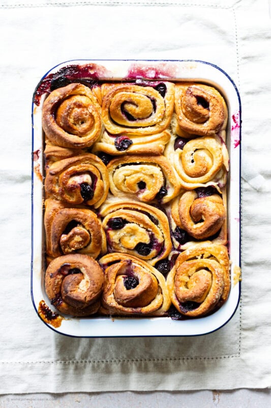 Un-iced lemon and blueberry rolls in a tray