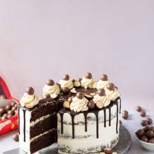 A slice being taken from a Malteser Drip Cake