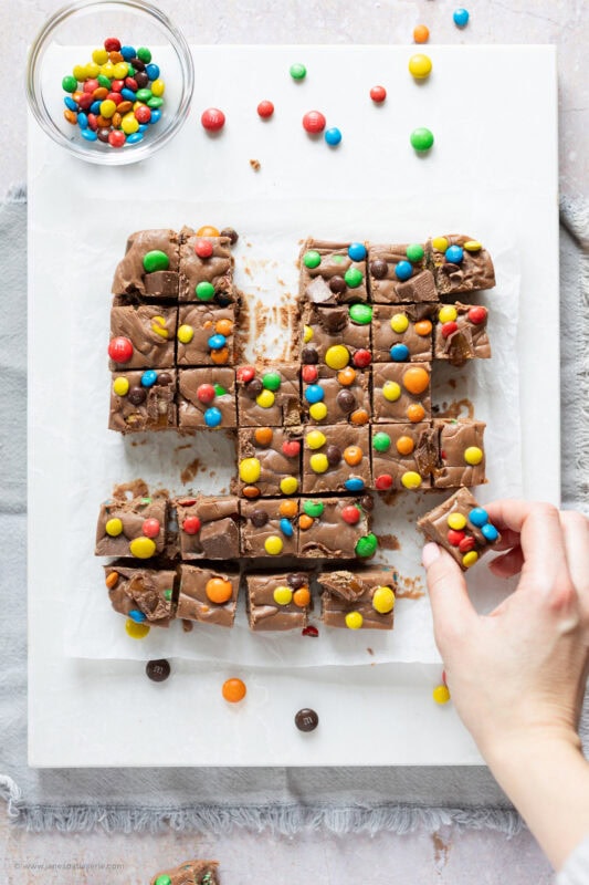 A hand taking a slice of microwave fudge