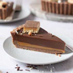 A single slice of Billionaires Tart on a white plate