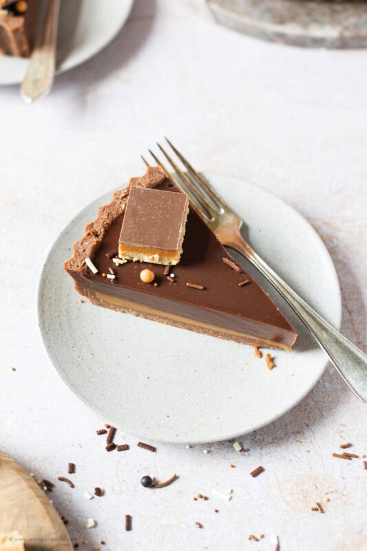 A slice of Billionaires Tart on a plate with a fork