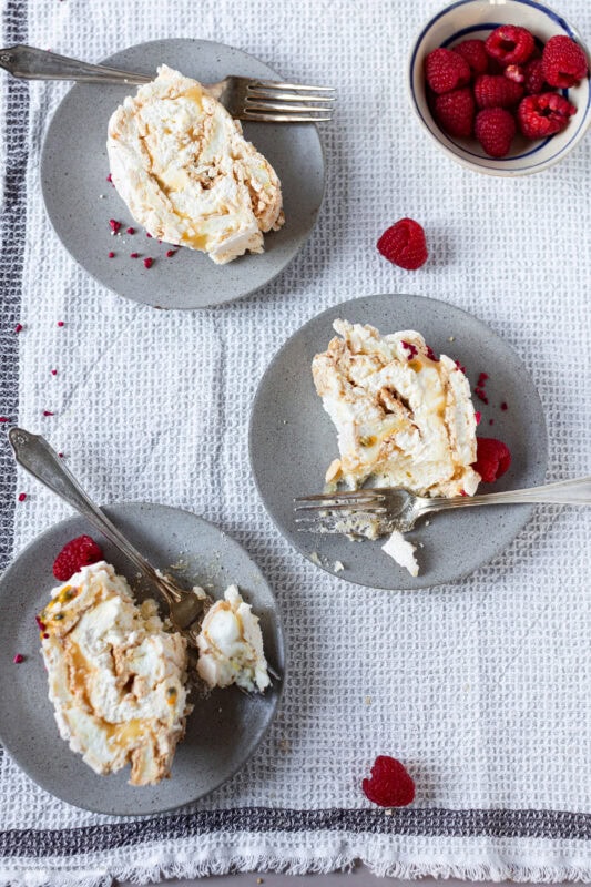 Lemon meringue roulade slices on plates with forks