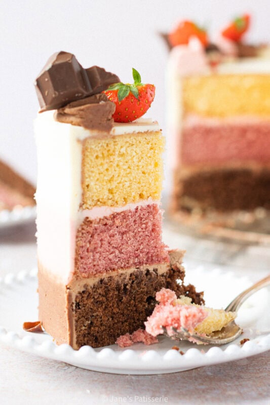 Half eaten slice of Neapolitan cake.
