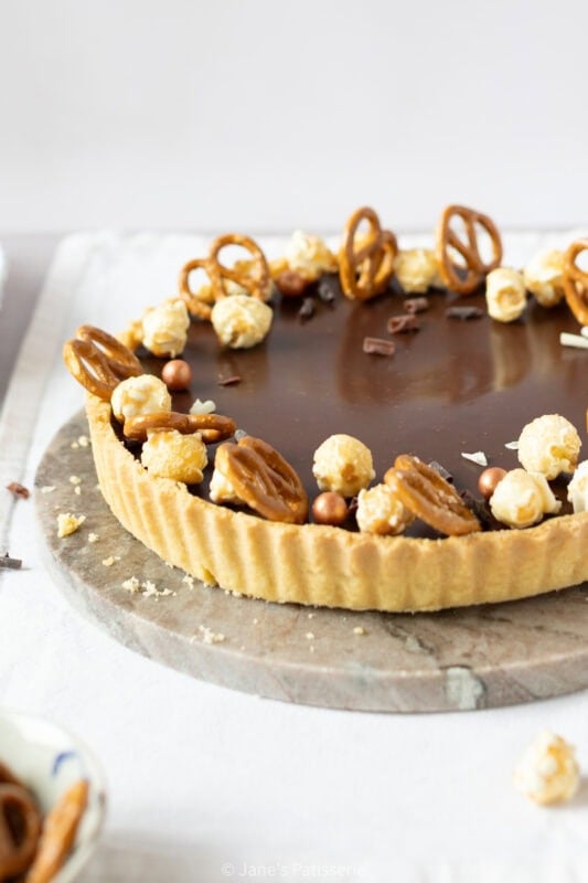 A whole Salted Caramel Tart served on a chopping board.