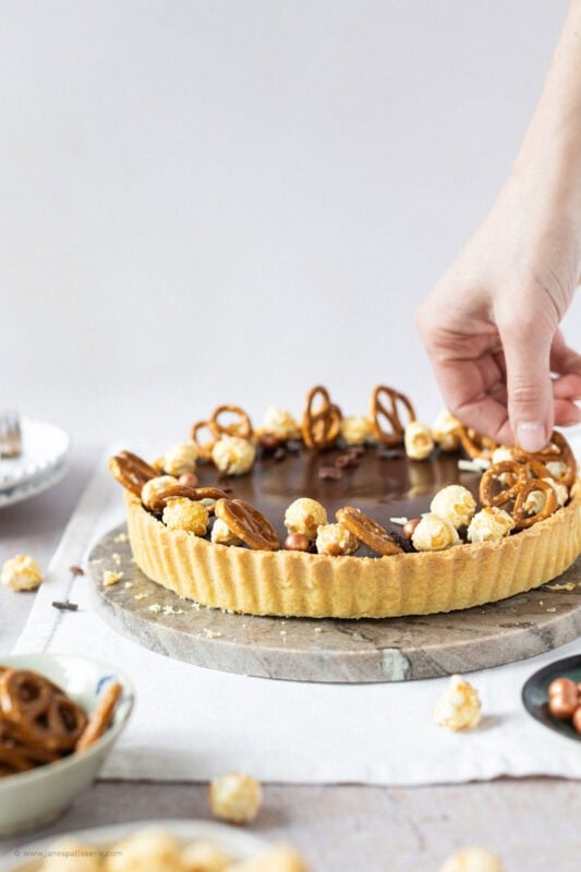The final decorations being placed on a Salted Caramel Tart
