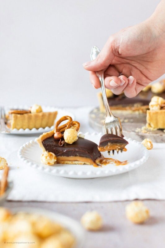 A fork taking a single bitesized piece of Salted Caramel Tart