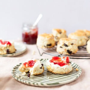 White Chocolate and Cranberry Scones on a plate with Jam and clotted cream.