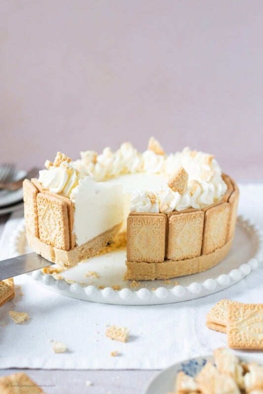 A slice being removed from a whole Custard cream cheesecake