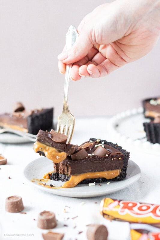 A fork taking a bite from a slice of no-bake rolo tart