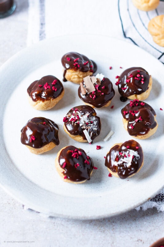 A top down shot of profiteroles on a white plate