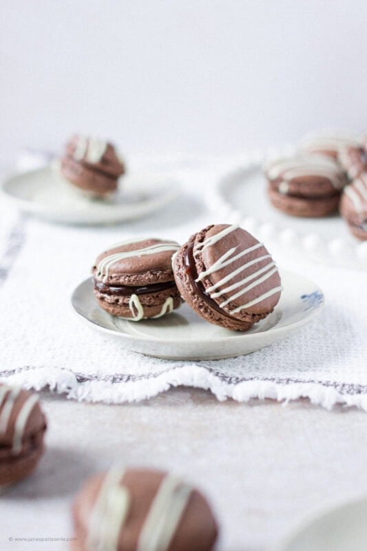 A small plate with two Triple Chocolate Macarons