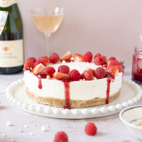 A Champagne Cheesecake with dripping coulis and strawberries