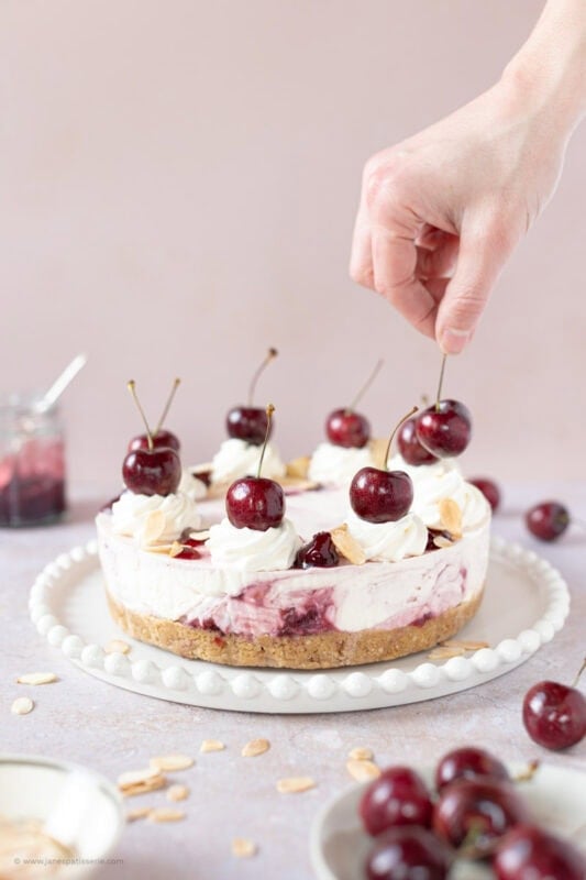 Decorating a Cherry Bakewell Cheesecake with fresh cherries