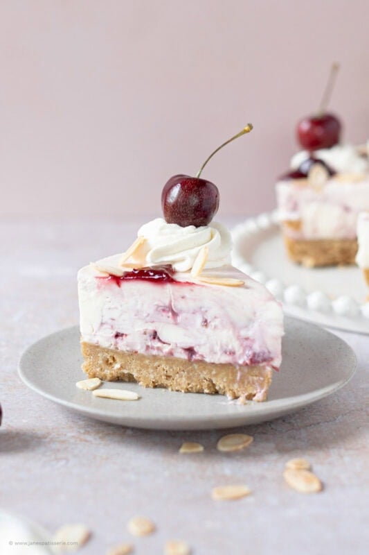A slice of Cherry Bakewell Cheesecake on a plate