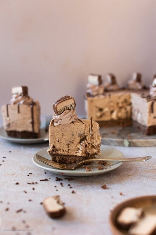 A bite missing from a slice of Double Decker Cheesecake