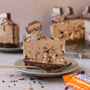 A slice of Double Decker Cheesecake with a bar wrapper in the foreground