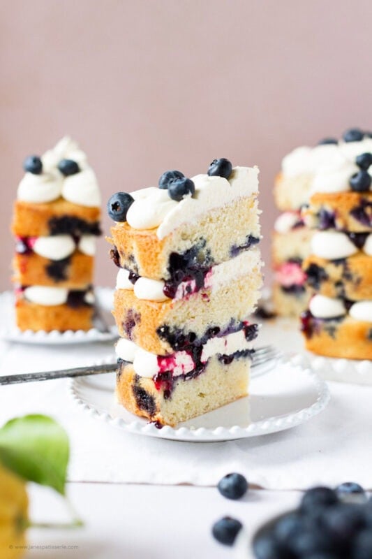 A slice of Lemon Blueberry Cake on a white plate