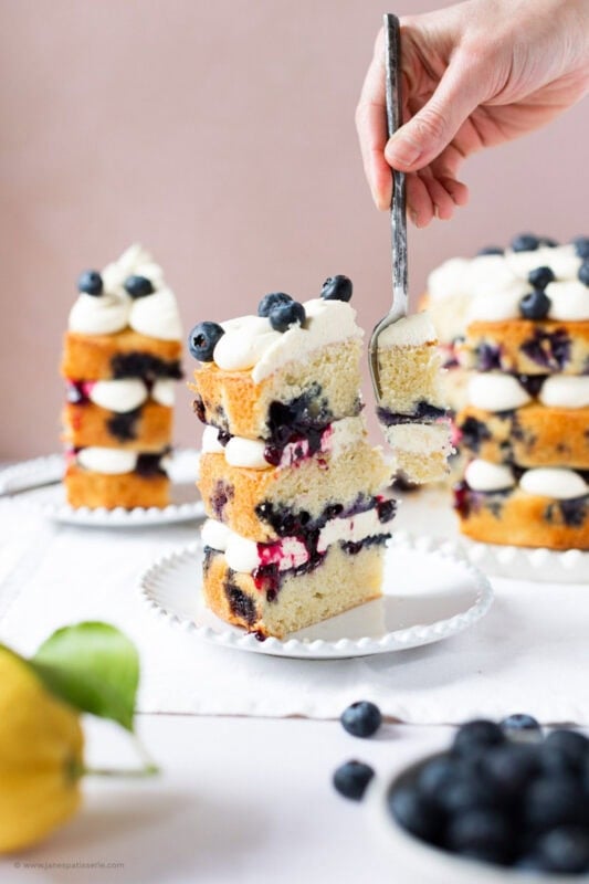 A fork cutting into a slice of Lemon Blueberry Cake