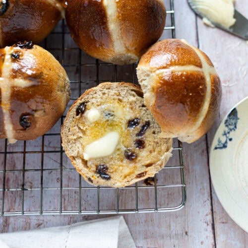 Buttered hot cross buns on a cooling rack