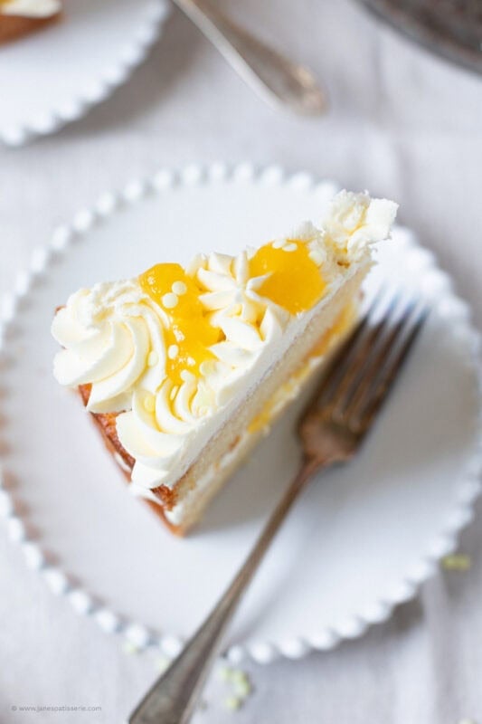 A slice of Lemon Celebration Cake on a white plate
