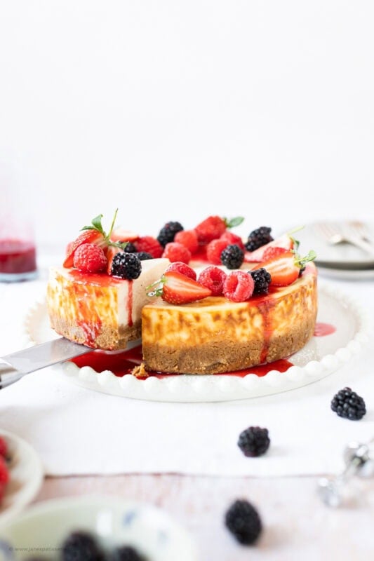 A slice cut into a full New York Cheesecake