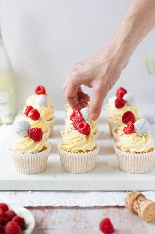 A hand decorating the final Prosecco Cupcakes