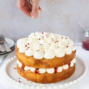 A hand decorating a Vanilla Cake - back to basics